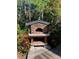 Close up of the stone pizza oven with lush foliage surrounding at 1875 Harmony Dr, Clearwater, FL 33756