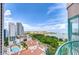 Sweeping city and harbor view from the building's balcony, showing a pool, trees, and city buildings at 288 Beach Ne Dr # 12C, St Petersburg, FL 33701