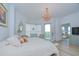 Cozy bedroom with chandelier, large windows, and exterior balcony access, featuring light wood-look flooring at 288 Beach Ne Dr # 12C, St Petersburg, FL 33701