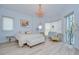 Bright bedroom featuring a light-colored chandelier, furniture and accents, with exterior balcony access at 288 Beach Ne Dr # 12C, St Petersburg, FL 33701