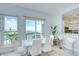 Bright dining area with white table, chairs, and stunning ocean views through large windows and sliding glass doors at 288 Beach Ne Dr # 12C, St Petersburg, FL 33701