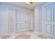 Hallway featuring beige striped wallpaper, tiled floors, and multiple white doors with gold trim at 288 Beach Ne Dr # 12C, St Petersburg, FL 33701
