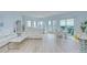 Bright and airy living room with floor to ceiling windows, light wood floors, and modern furniture at 288 Beach Ne Dr # 12C, St Petersburg, FL 33701