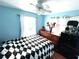 Bright bedroom with a checkered bedspread, light blue walls and window at 3110 W Haya St, Tampa, FL 33614
