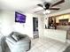 Inviting living space featuring tiled floors, a gray chair, and an open transition into the kitchen at 3110 W Haya St, Tampa, FL 33614