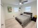 Well lit bedroom with a ceiling fan, light colored flooring and modern wall decorations at 3120 Meadow Lake Ave, Largo, FL 33771