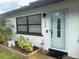 Close up of front entrance with white door, black accents, and fresh landscaping at 3120 Meadow Lake Ave, Largo, FL 33771