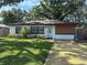 Charming single story home with a well-maintained lawn and wood accent wall at 3120 Meadow Lake Ave, Largo, FL 33771