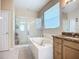 Bright bathroom featuring a soaking tub, separate glass shower, and vanity with stone countertops at 3409 61St E Ter, Ellenton, FL 34222