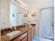 Spacious bathroom with a dual sink vanity, granite countertops, and walk out access at 3409 61St E Ter, Ellenton, FL 34222