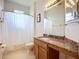 Bright bathroom featuring granite countertops, a large mirror, and a shower with curtain rod at 3409 61St E Ter, Ellenton, FL 34222