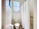 Clean bathroom featuring a toilet, shower with curtain, and small window providing natural light at 3409 61St E Ter, Ellenton, FL 34222
