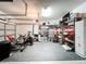 Well-lit garage space with rubber flooring, shelving, and fitness equipment offers versatility at 3409 61St E Ter, Ellenton, FL 34222