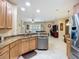 Open-concept kitchen featuring stainless steel appliances, granite countertops, and wooden cabinets at 3409 61St E Ter, Ellenton, FL 34222