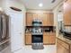 Modern kitchen featuring stainless steel appliances, wooden cabinets, and a granite backsplash at 3409 61St E Ter, Ellenton, FL 34222