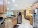 Open-concept kitchen featuring stainless steel appliances, granite countertops, and wooden cabinets at 3409 61St E Ter, Ellenton, FL 34222