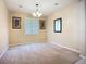 Neutral carpeted living room with a chandelier, a window with white shutters, and neutral colored walls at 3409 61St E Ter, Ellenton, FL 34222