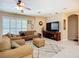 Inviting living room features neutral tones, a ceiling fan, plush furniture, and a large television at 3409 61St E Ter, Ellenton, FL 34222