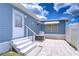 Exterior view of backyard patio with white railing and steps; blue siding offers a clean, modern look at 35014 Carl Ave, Zephyrhills, FL 33541
