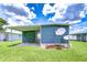 Exterior view of home with a patio and expansive grassy yard; a satellite dish is visible on the side at 35014 Carl Ave, Zephyrhills, FL 33541