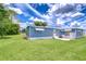Blue exterior with white trim, awning, and a spacious lawn on a sunny day at 35014 Carl Ave, Zephyrhills, FL 33541