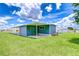 Exterior view of home with large lawn, patio, and satellite dish at 35014 Carl Ave, Zephyrhills, FL 33541