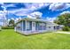 Quaint home with a welcoming entrance, freshly cut lawn, and blue siding under a sunny sky at 35014 Carl Ave, Zephyrhills, FL 33541