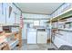 Functional laundry room equipped with a washer and dryer, pegboard and plenty of shelving for ample storage at 35014 Carl Ave, Zephyrhills, FL 33541