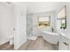 Bright bathroom featuring a soaking tub, tiled shower, and wood-look floors at 380 Colony Point S Rd, St Petersburg, FL 33705