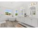 Bright bathroom with dual sinks, modern tub, gold fixtures, and wood-look flooring at 380 Colony Point S Rd, St Petersburg, FL 33705