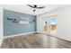 Bedroom featuring a balcony, blue accent wall, and wood-look flooring at 380 Colony Point S Rd, St Petersburg, FL 33705