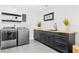 Modern laundry room with sleek gray cabinetry, butcher block countertop, and stylish decor for efficient chore management at 380 Colony Point S Rd, St Petersburg, FL 33705