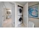 Laundry area featuring a stacked washer and dryer, doorway to bathroom, and tile floors at 4 Belleview Blvd # 305, Belleair, FL 33756