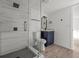 Modern bathroom featuring a glass-enclosed shower with hexagon tile floor and dark blue vanity at 4020 N Falkenburg Rd, Tampa, FL 33610