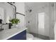 Beautiful bathroom with navy vanity, quartz countertop, framed mirror and modern glass shower at 4020 N Falkenburg Rd, Tampa, FL 33610