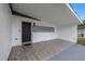 Covered entryway featuring stylish tile flooring, a dark front door, and exterior lighting at 4020 N Falkenburg Rd, Tampa, FL 33610