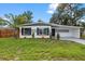 Charming single-story home with well-manicured lawn, palm tree, and attractive gray and white exterior at 4020 N Falkenburg Rd, Tampa, FL 33610