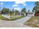 Attractive home exterior with concrete driveway, landscaped lawn, modern white picket fence and updated facade at 4020 N Falkenburg Rd, Tampa, FL 33610
