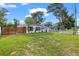 Landscaped front yard featuring a modern home, wooden fence, and healthy green grass at 4020 N Falkenburg Rd, Tampa, FL 33610