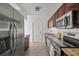 Updated kitchen featuring stainless steel appliances, granite countertops, and dark wood cabinets at 4020 N Falkenburg Rd, Tampa, FL 33610