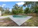 A kidney-shaped pool bordered by mature trees and wood fencing in backyard at 4020 N Falkenburg Rd, Tampa, FL 33610