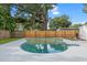 A beautiful turquoise pool surrounded by concrete with a new wooden fence at 4020 N Falkenburg Rd, Tampa, FL 33610