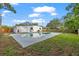 A backyard showcases a kidney-shaped pool, partially surrounded by green grass at 4020 N Falkenburg Rd, Tampa, FL 33610