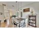 Bright dining area with a wooden table, white chairs, and stylish pendant lighting creating an inviting atmosphere at 4415 Muirfiled Dr, Bradenton, FL 34210