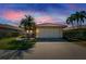 Home at dusk featuring a tile roof, well-maintained landscaping, and an attached two-car garage at 4415 Muirfiled Dr, Bradenton, FL 34210