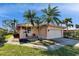 Home featuring a tile roof, chairs on front porch, neat landscaping, and an attached two-car garage at 4415 Muirfiled Dr, Bradenton, FL 34210
