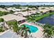 Aerial view of the community pool, showcasing the lounge area, tropical landscaping, and surrounding homes at 4415 Muirfiled Dr, Bradenton, FL 34210