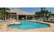 Community pool featuring crystal-clear water, lounge chairs, tables and meticulously kept landscaping at 4415 Muirfiled Dr, Bradenton, FL 34210