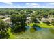 Expansive aerial view of a neighborhood with lush greenery, serene pond, and well-maintained properties at 4511 Preston Woods Dr, Valrico, FL 33596