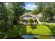 Aerial shot showcasing a screened-in pool area, tropical landscaping, and tranquil pond views at 4511 Preston Woods Dr, Valrico, FL 33596